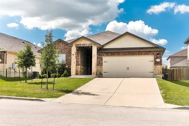 a front view of a house with a yard and garage