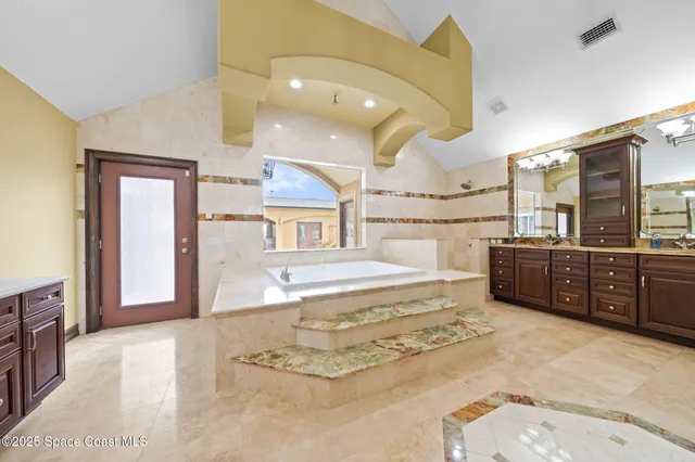 a bathroom with a granite countertop sink a toilet a mirror and shower