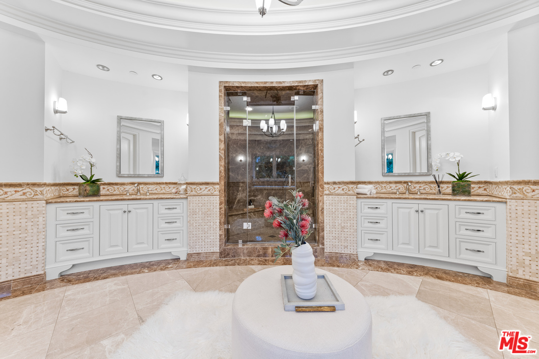210 North Rockingham Avenue Los Angeles, CA 90049 - Photo 29 of 50 a spacious bathroom with a granite countertop sink and a mirror