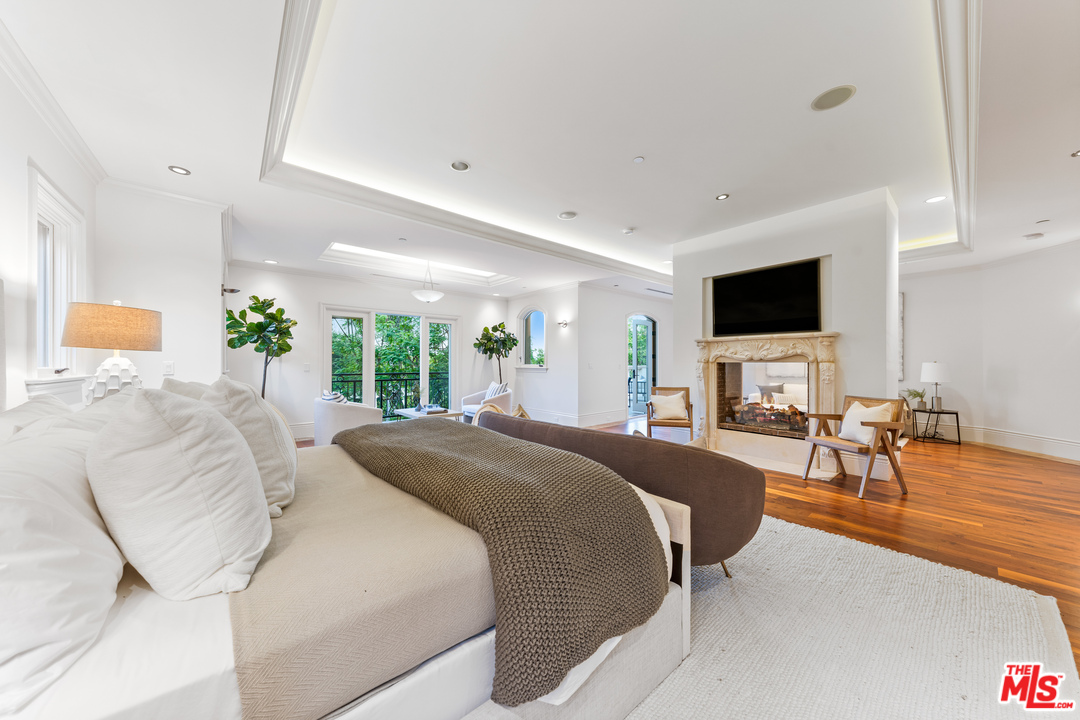 210 North Rockingham Avenue Los Angeles, CA 90049 - Photo 36 of 50 a spacious bedroom with a large bed and a flat screen tv