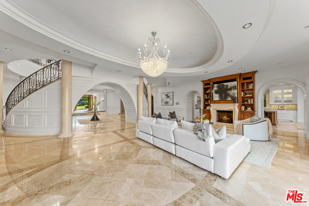 210 North Rockingham Avenue Los Angeles, CA 90049 - Photo 7 of 50 a living room with furniture a chandelier and a fireplace