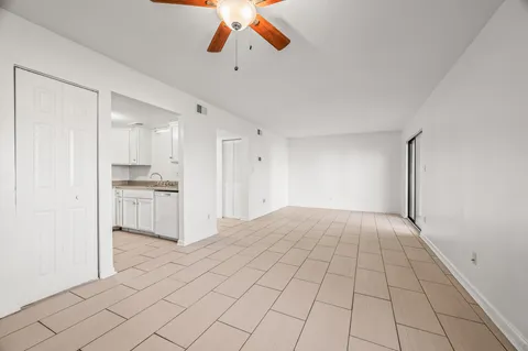a view of kitchen and empty room with windows