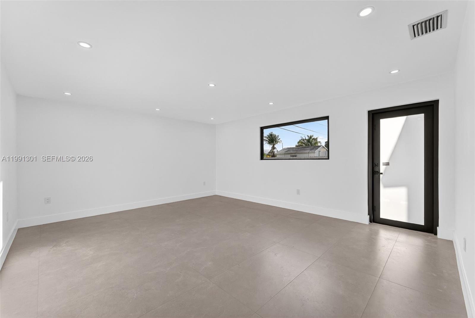 10445 Southwest 149th Terrace Miami, FL 33176 - Photo 7 of 19 an empty room with wooden floor and windows