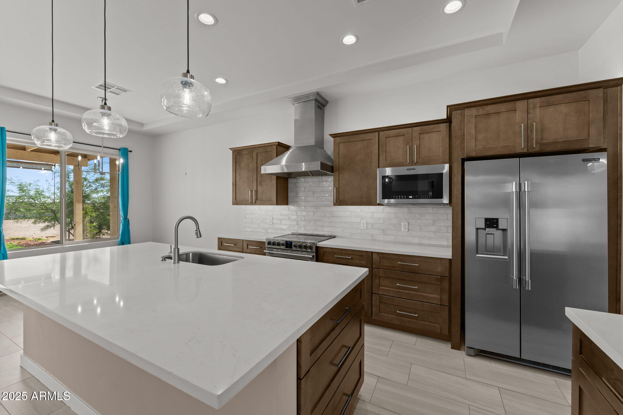 23012 Peak View Road Wittmann, AZ 85361 - Photo 10 of 44 a kitchen with stainless steel appliances granite countertop a sink a refrigerator and a kitchen island