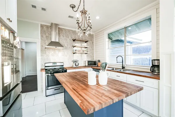 a kitchen with stainless steel appliances granite countertop a sink a stove and a window