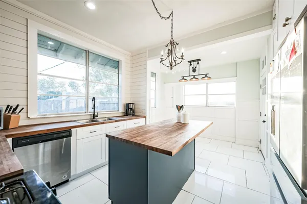 a kitchen with a sink a stove a refrigerator and chandelier