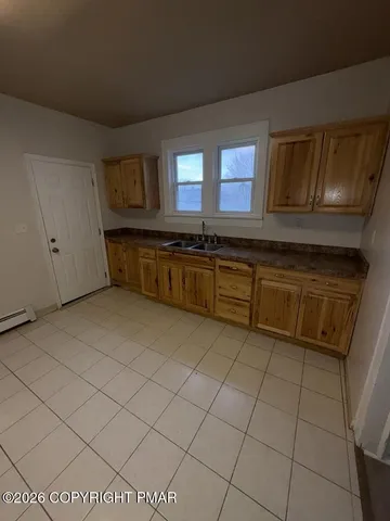 a kitchen with stainless steel appliances granite countertop a refrigerator a stove top oven and a sink with granite countertops