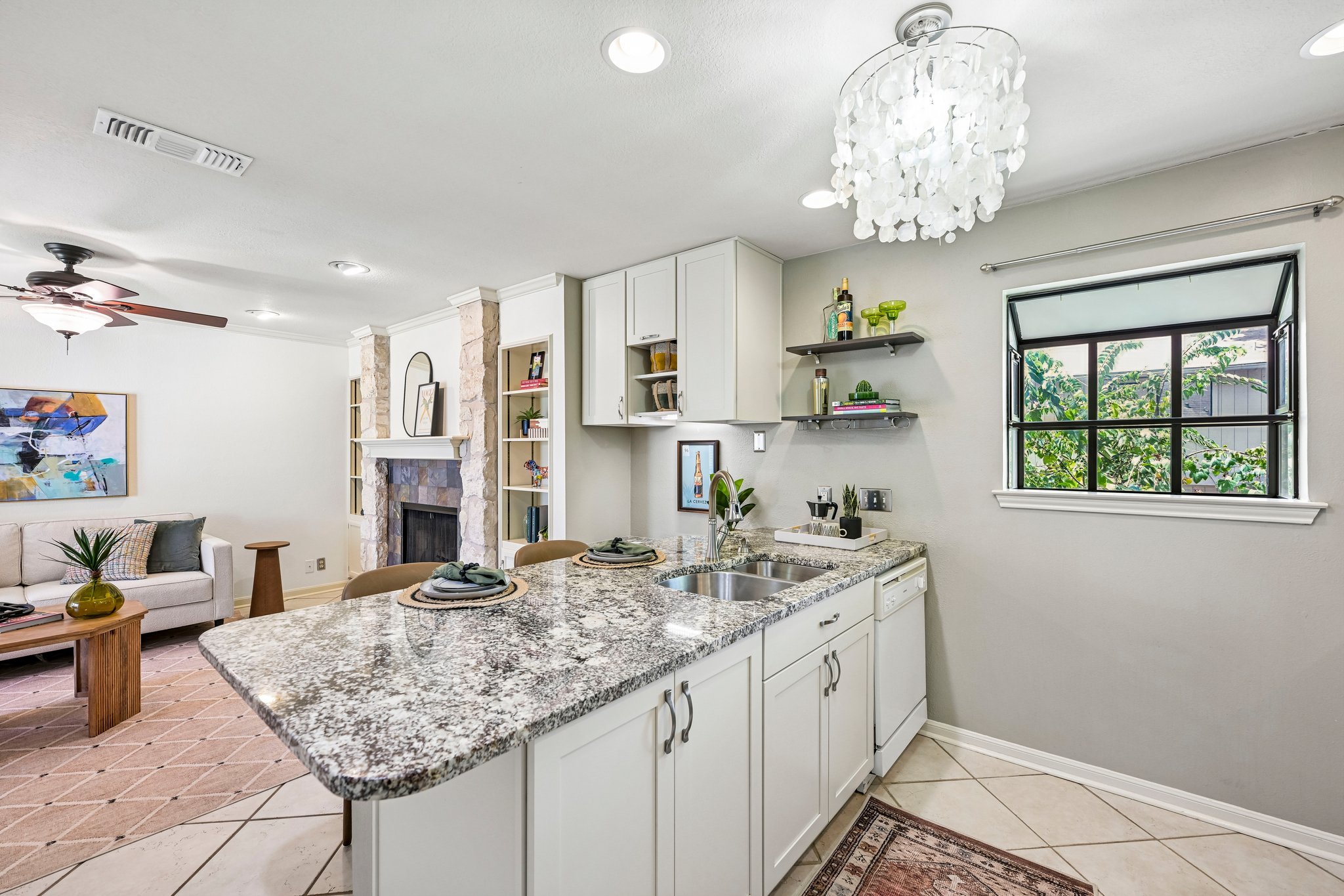 2412 Enfield Road, Unit 8 Austin, TX 78703 - Photo 19 of 34 Mid Continent Cabinetry, granite countertops, stainless appliances, open shelving, and a leafy kitchen window. Small kitchen, serious resume.