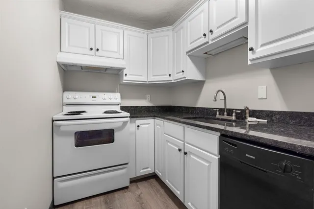 a kitchen with granite countertop white cabinets and white appliances