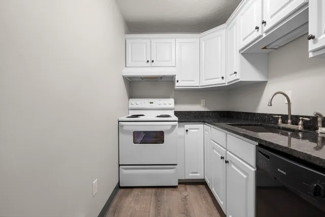 a kitchen with granite countertop white cabinets and white appliances