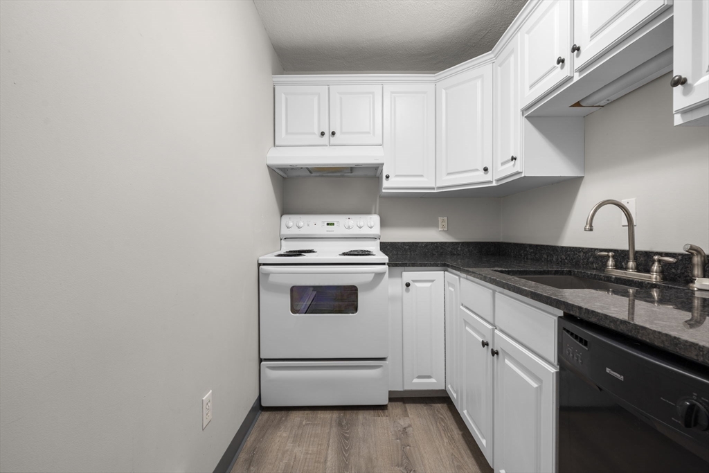 19 Washington Street, Unit 2 Haverhill, MA 01832 - Photo 3 of 20 a kitchen with granite countertop white cabinets and white appliances