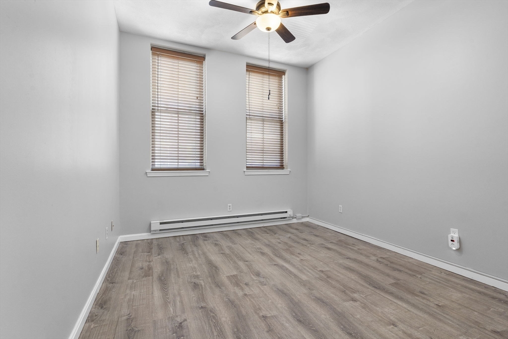 19 Washington Street, Unit 2 Haverhill, MA 01832 - Photo 8 of 20 an empty room with wooden floor fan and windows