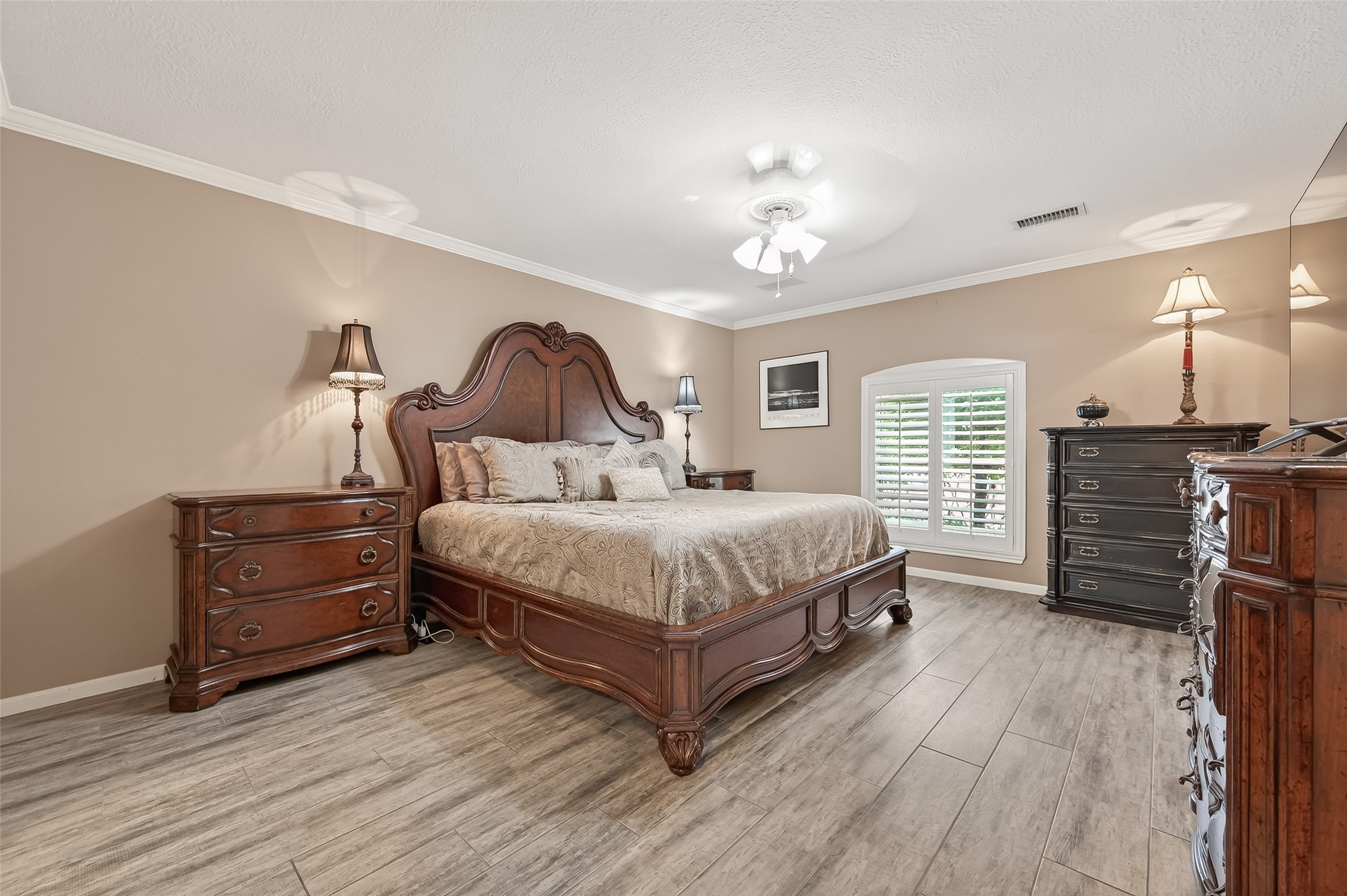 7310 Maidstone Lane Houston, TX 77095 - Photo 16 of 40 Dreamy primary bedroom (16X13) is located downstairs with tile flooring, crown moldings and shuttered windows.