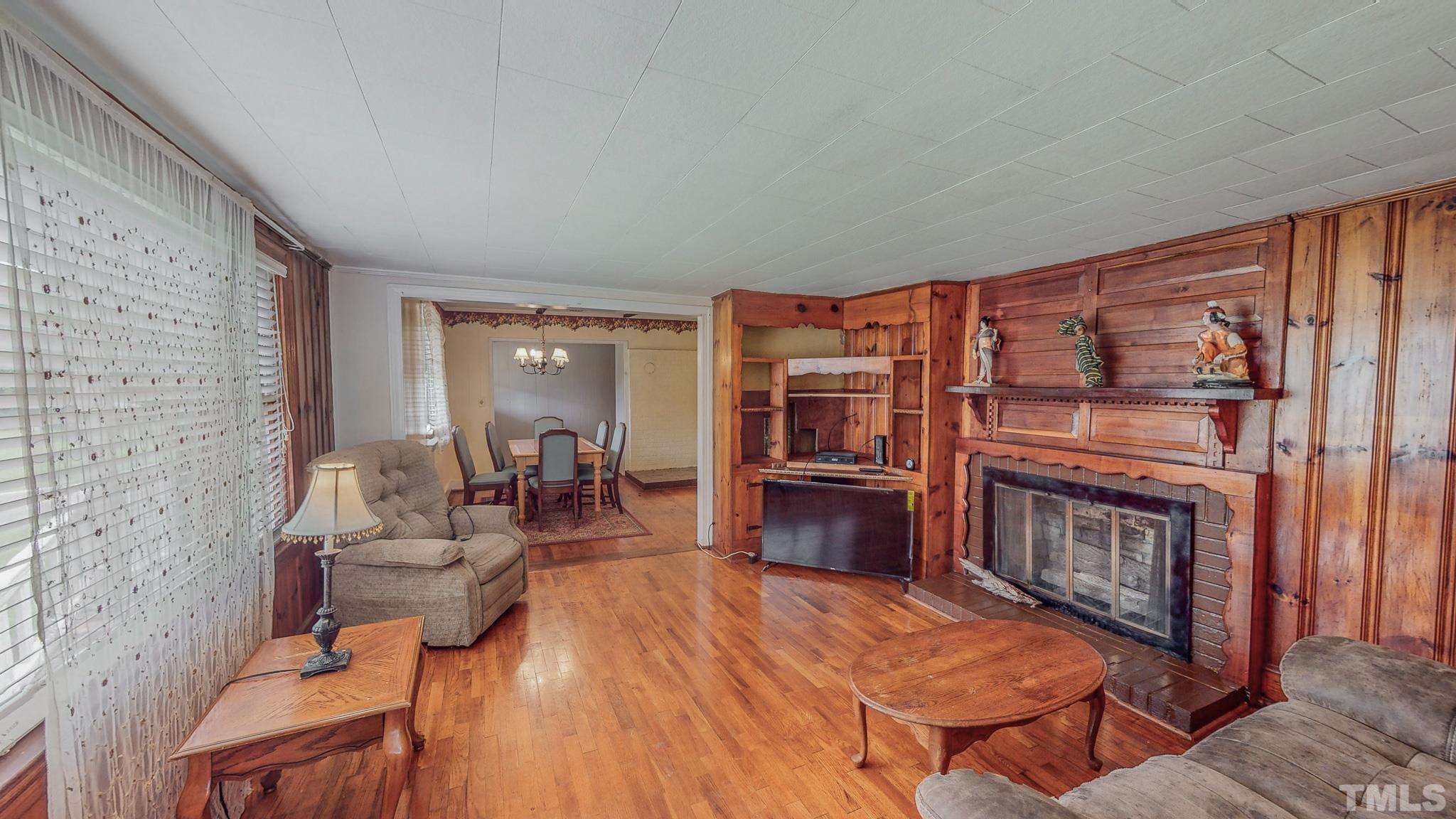 1556 Gentry-Dunkley Road Roxboro, NC 27574 - Photo 2 of 47 a living room with furniture a fireplace and a flat screen tv