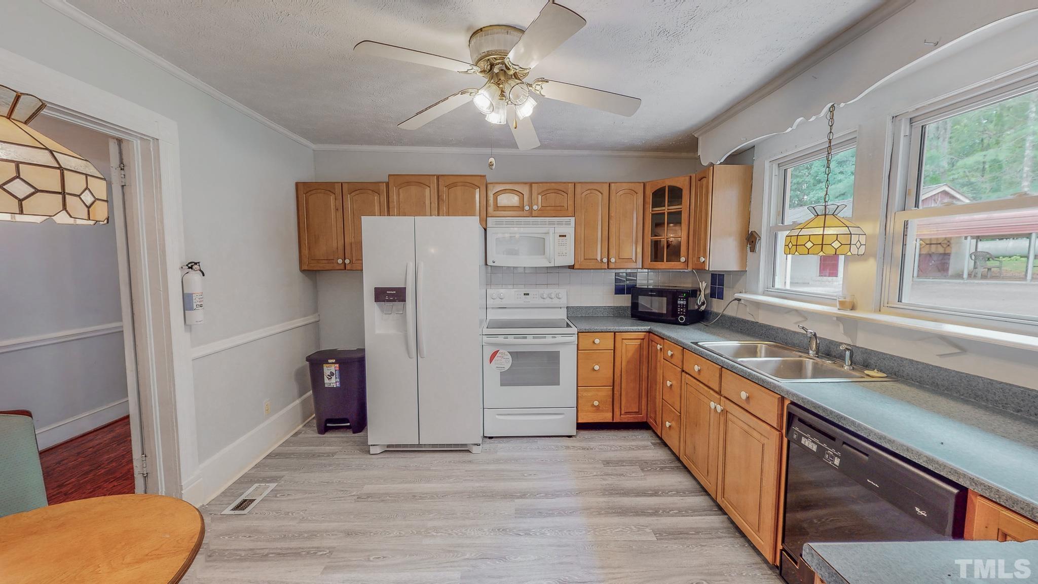 1556 Gentry-Dunkley Road Roxboro, NC 27574 - Photo 23 of 47 a kitchen with stainless steel appliances a refrigerator a sink a stove a refrigerator cabinets and furniture