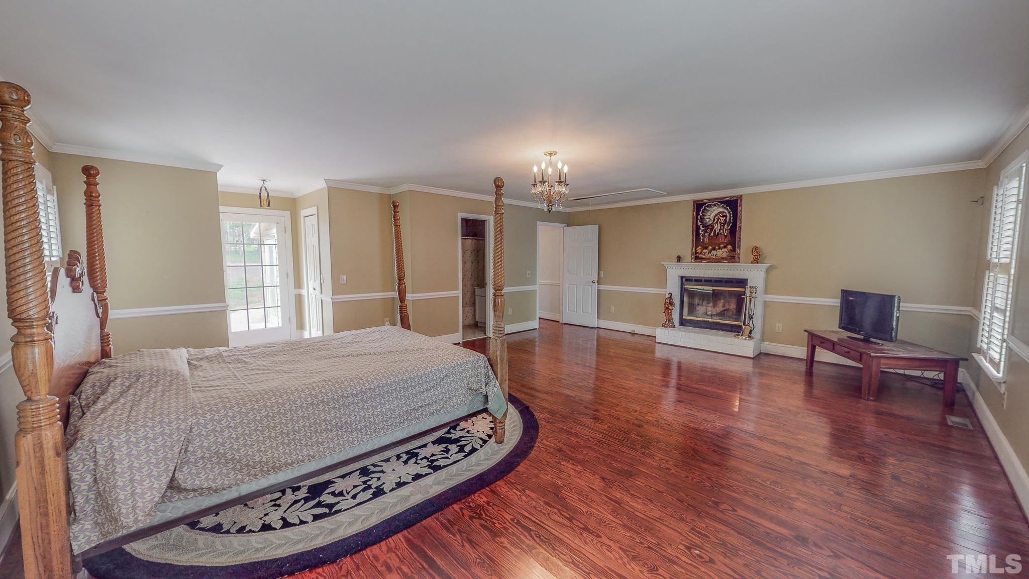 1556 Gentry-Dunkley Road Roxboro, NC 27574 - Photo 30 of 47 a spacious bedroom with a bed a table and chair