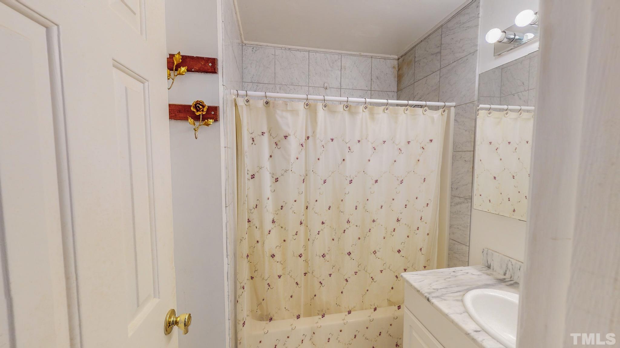 1556 Gentry-Dunkley Road Roxboro, NC 27574 - Photo 31 of 47 a bathroom with a sink a toilet and shower curtain