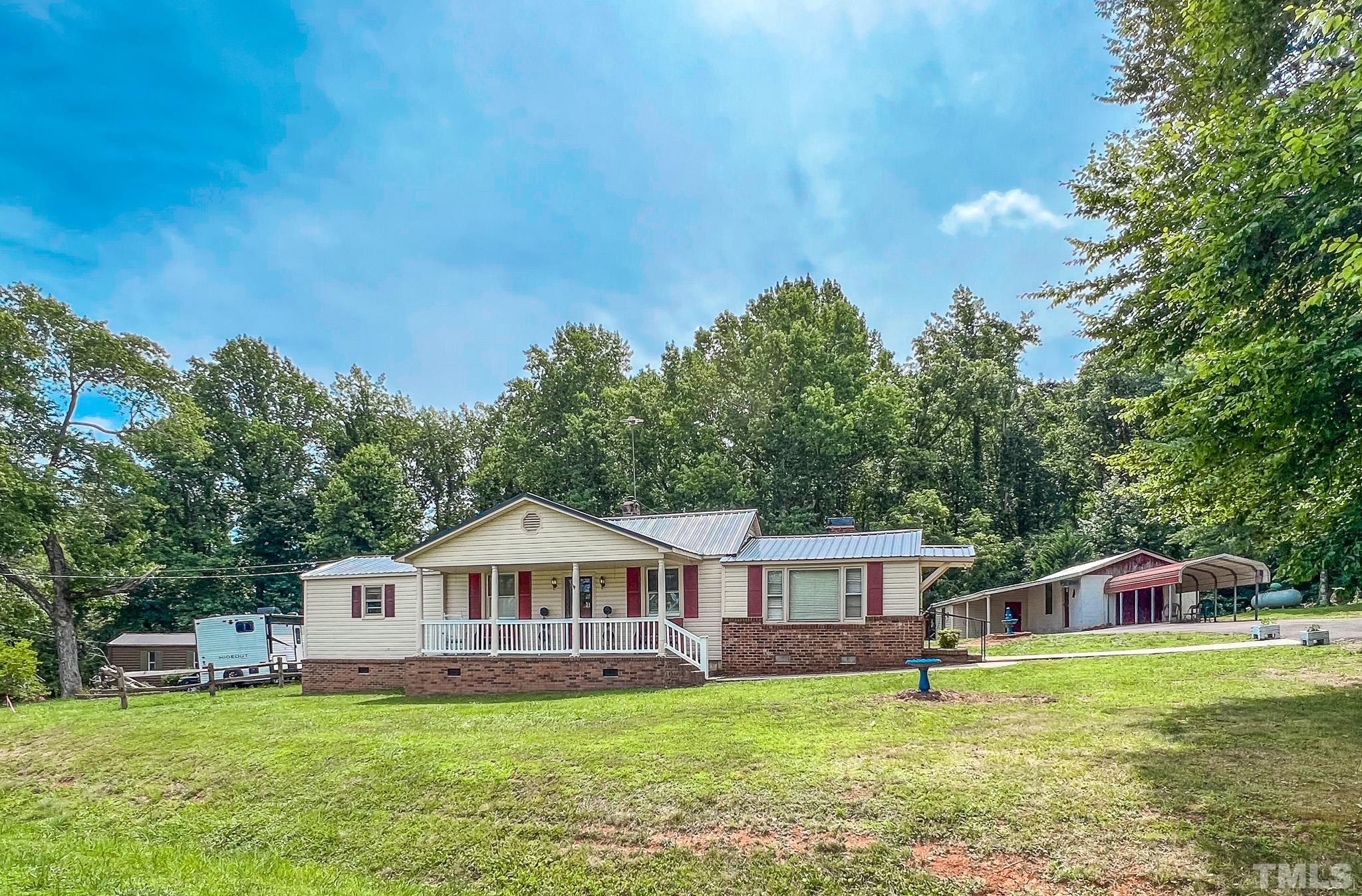 1556 Gentry-Dunkley Road Roxboro, NC 27574 - Photo 36 of 47 a front view of a house with a garden