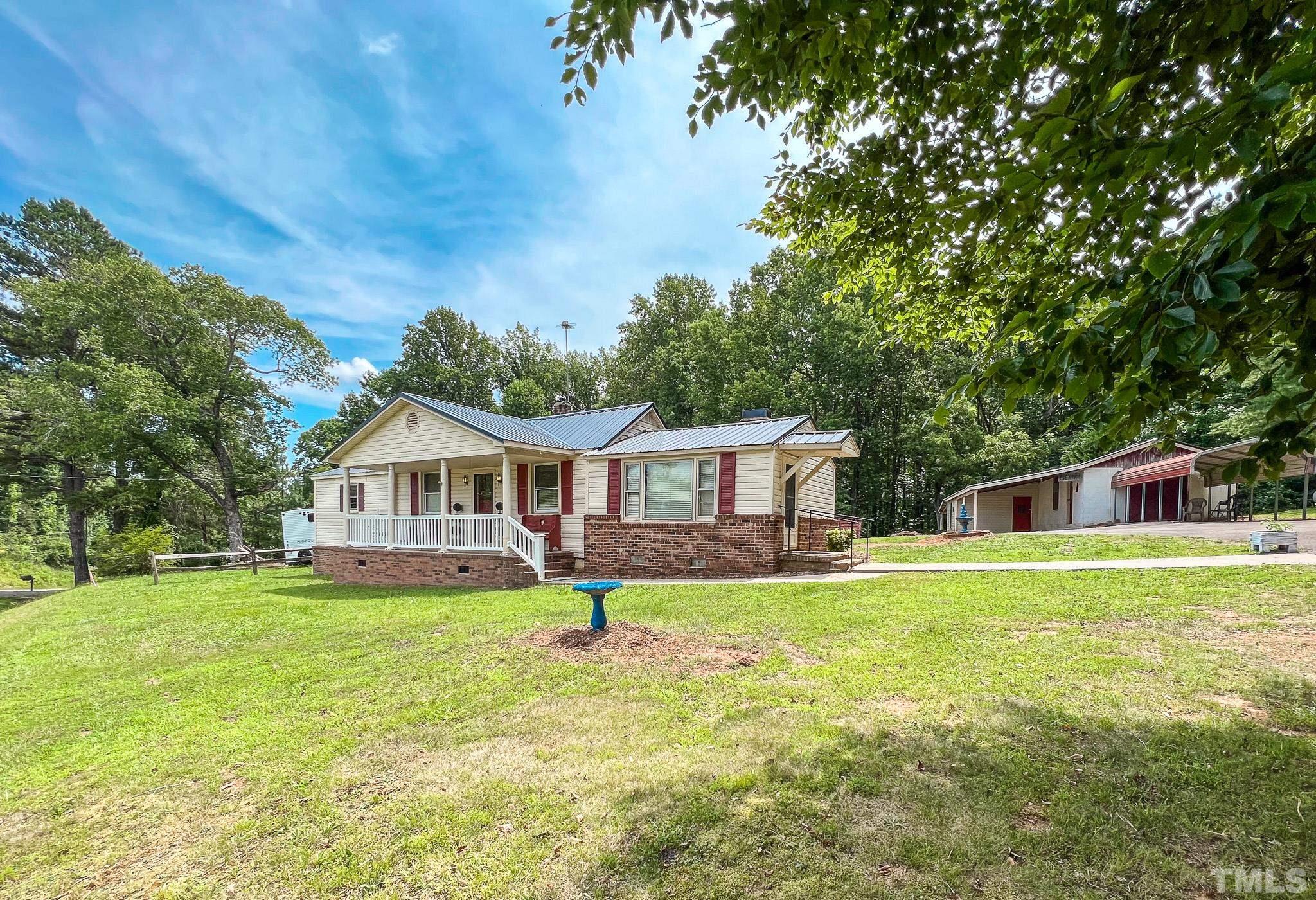1556 Gentry-Dunkley Road Roxboro, NC 27574 - Photo 40 of 47 a house that is sitting in a big yard with large trees