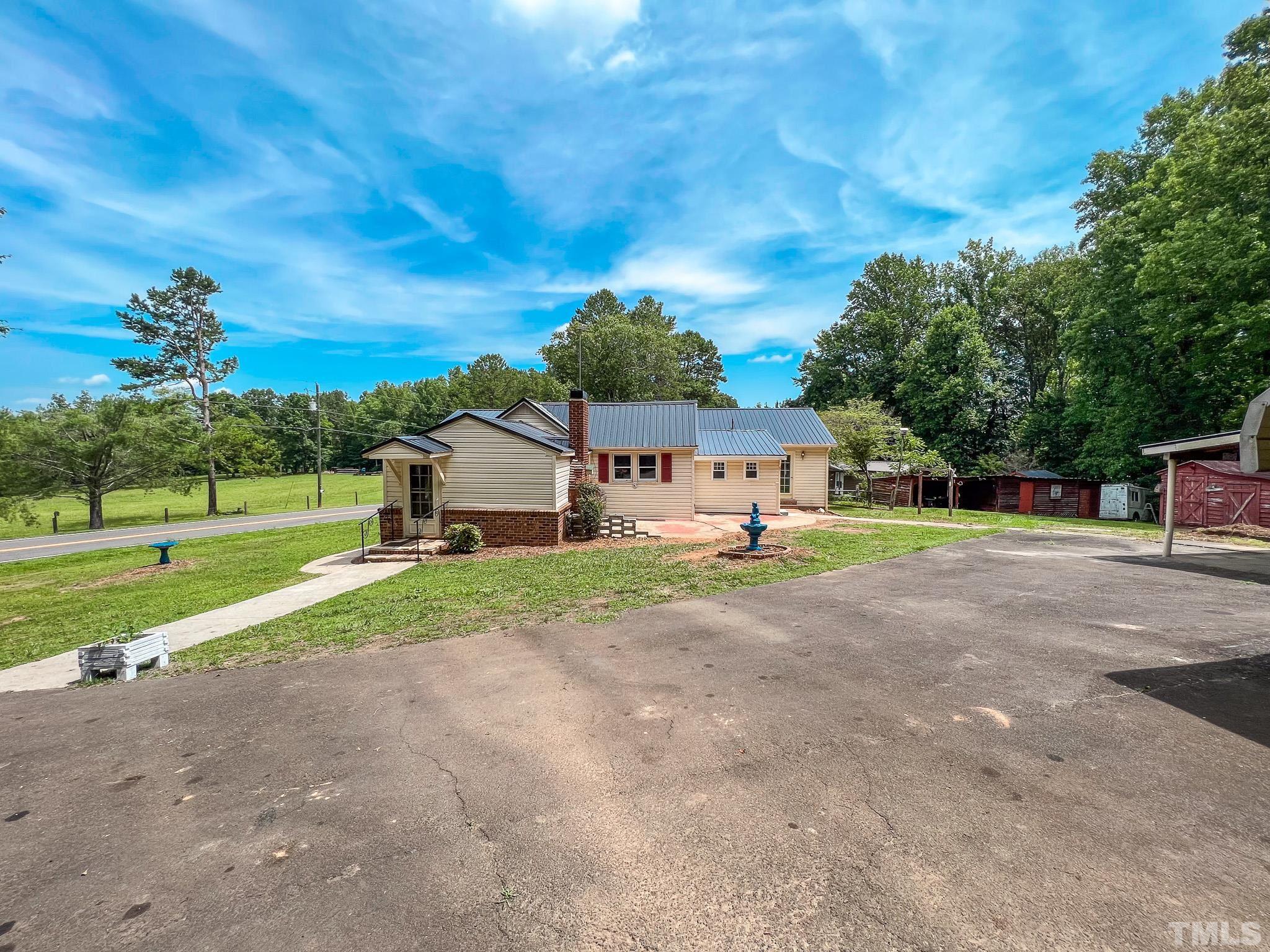 1556 Gentry-Dunkley Road Roxboro, NC 27574 - Photo 42 of 47 a front view of a house with a yard and garage
