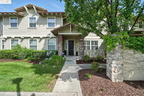 a front view of a house with yard and green space
