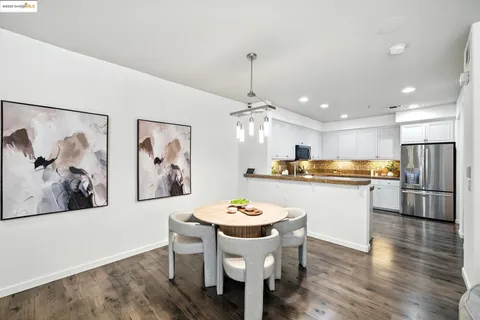 a kitchen with a refrigerator and white cabinets