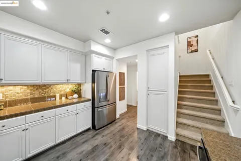 a kitchen with granite countertop cabinets and refrigerator