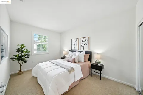 a bedroom with a large bed and a potted plant