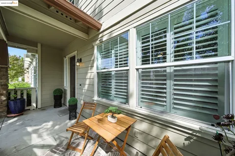 a backyard of a house with sofas table and chairs
