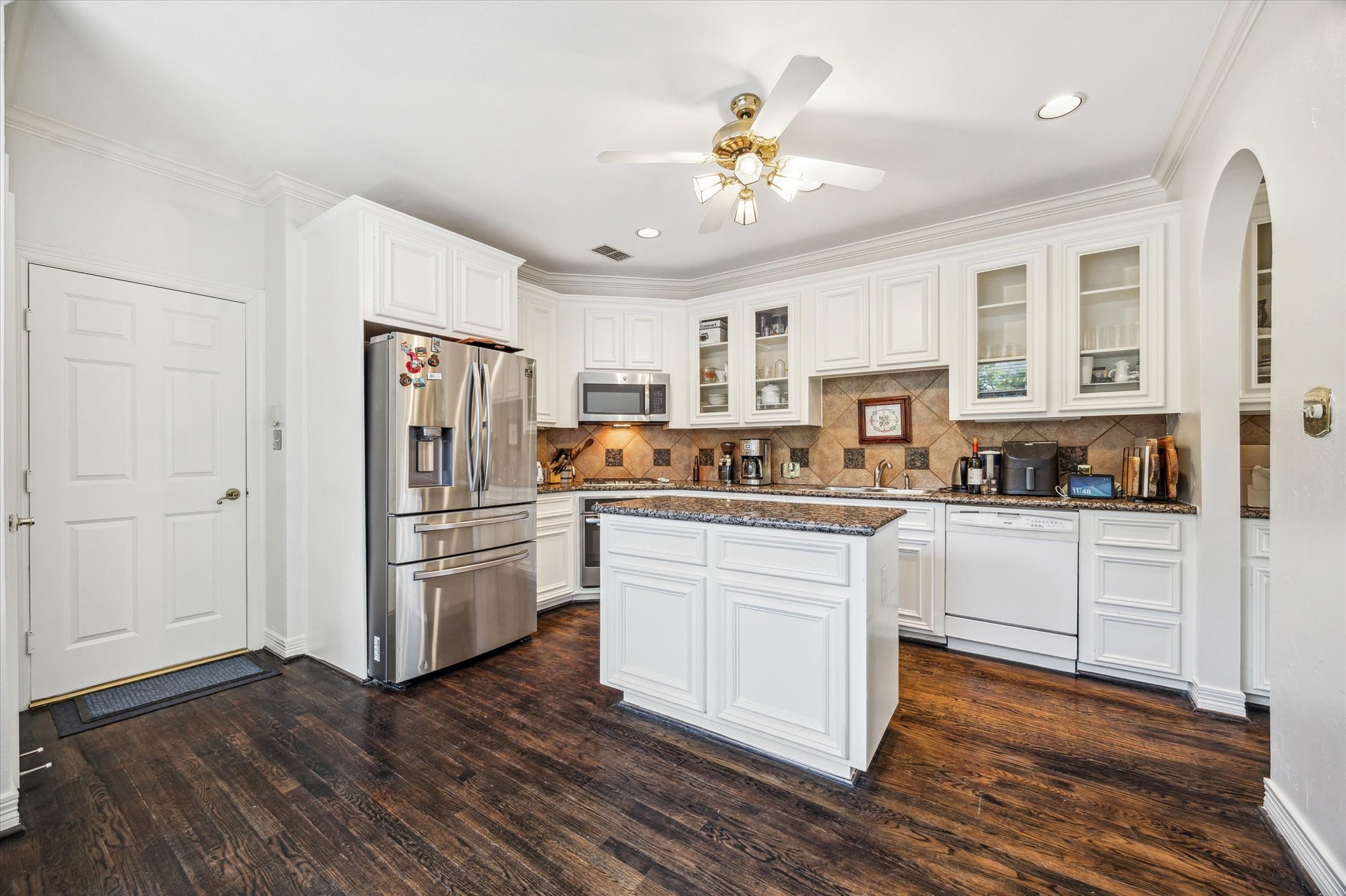 1202 Marconi Street Houston, TX 77019 - Photo 7 of 23 a kitchen with a refrigerator and white cabinets