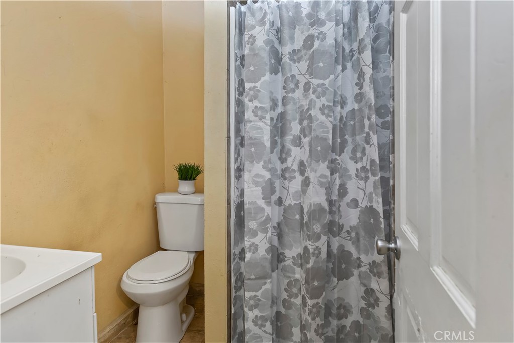 617 South Chester Avenue Compton, CA 90221 - Photo 26 of 34 a white toilet sitting next to a shower curtain