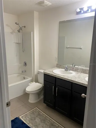 a bathroom with a double vanity sink toilet mirror and bathtub