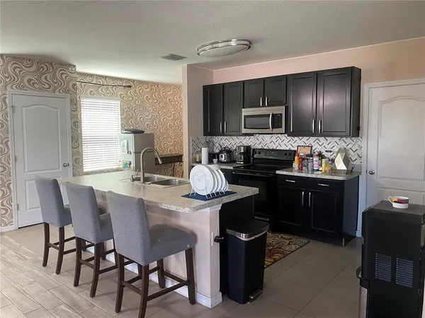 a kitchen with a sink and chairs