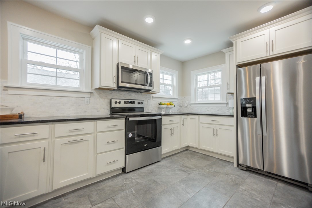 3553 Avalon Road Cleveland, OH 44120 - Photo 11 of 39 Kitchen featuring tasteful backsplash, appliances with stainless steel finishes, light tile floors, and white cabinetry