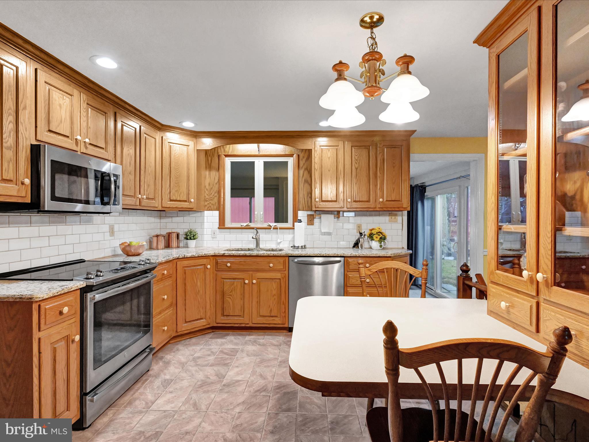 827 Pine Hill Road Lititz, PA 17543 - Photo 6 of 34 a large kitchen with stainless steel appliances granite countertop a stove a sink dishwasher a dining table and chairs with wooden floor