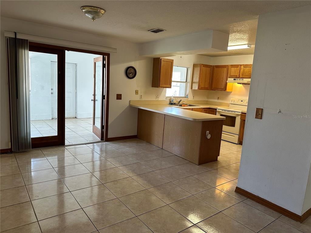 2454 Pine Chase Circle St. Cloud, FL 34769 - Photo 3 of 10 a large kitchen with granite countertop a stove a sink and a refrigerator