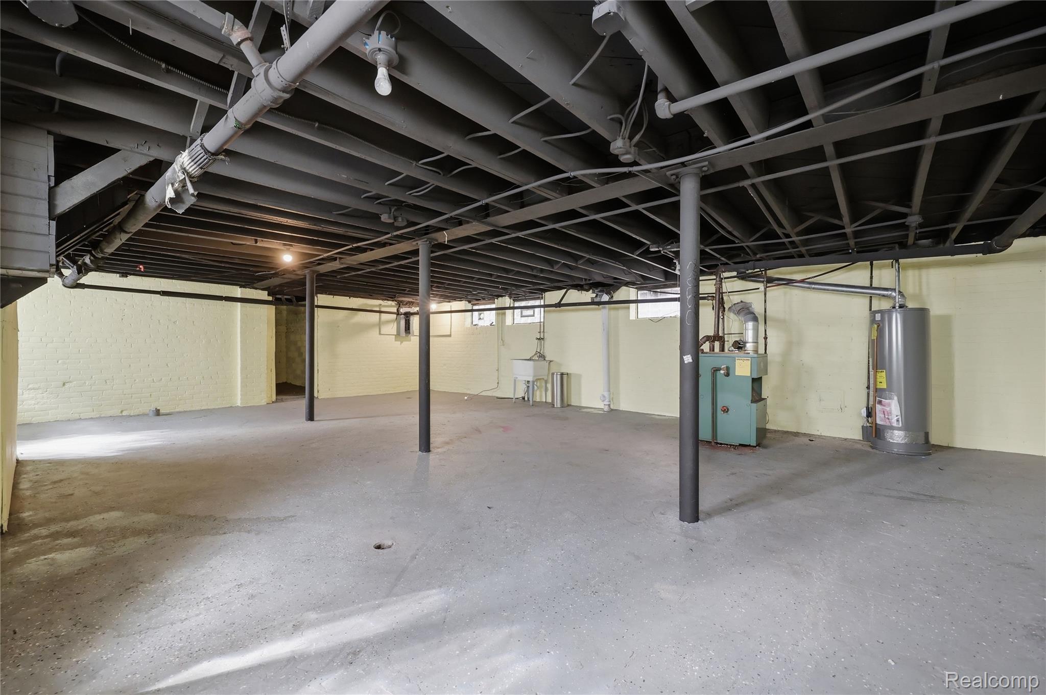 1945 Atkinson Street Detroit, MI 48206 - Photo 37 of 49 Spacious unfinished basement with painted concrete flooring and exposed ceiling beams