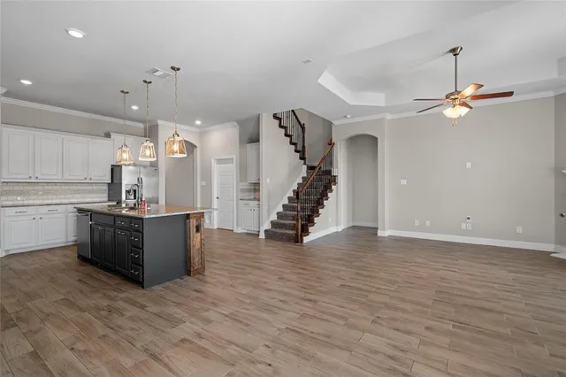 a large kitchen with cabinets and wooden floor