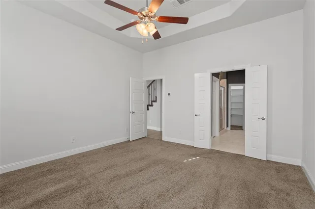 an empty room with closet and a chandelier fan