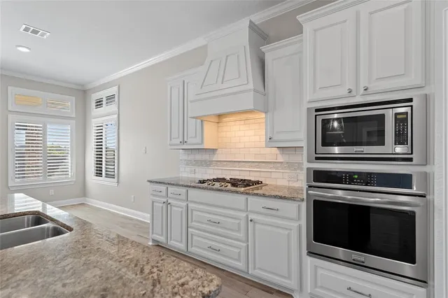 a kitchen with granite countertop white cabinets stainless steel appliances and sink
