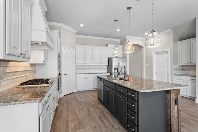 a kitchen with a stove sink and cabinets