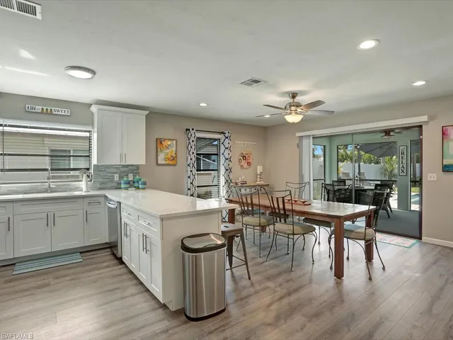 a open kitchen with stainless steel appliances granite countertop a table chairs and a stove