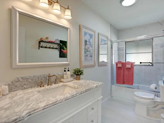 a bathroom with a granite countertop sink mirror vanity and toilet