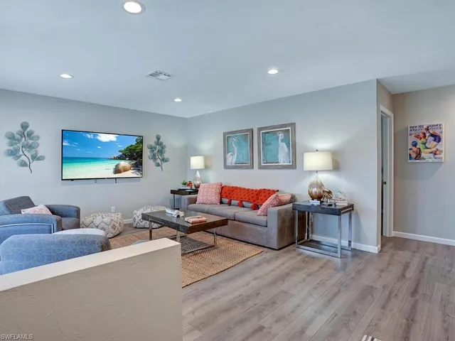 a living room with furniture and a wooden floor