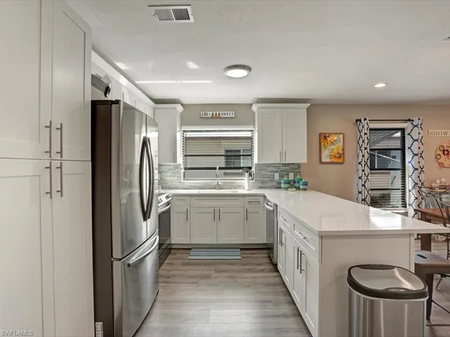 a kitchen with a refrigerator a sink and cabinets