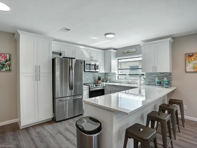a kitchen with kitchen island a wooden floor and white appliances