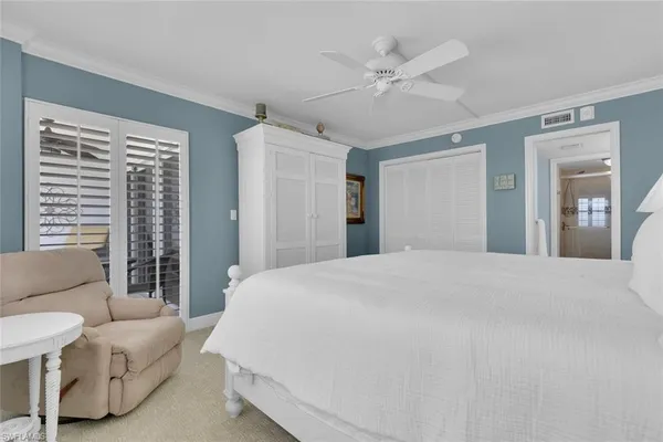 a spacious bedroom with a bed a couch and a large window