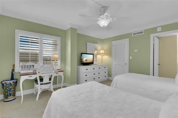 a bedroom with a bed a chair and a large window