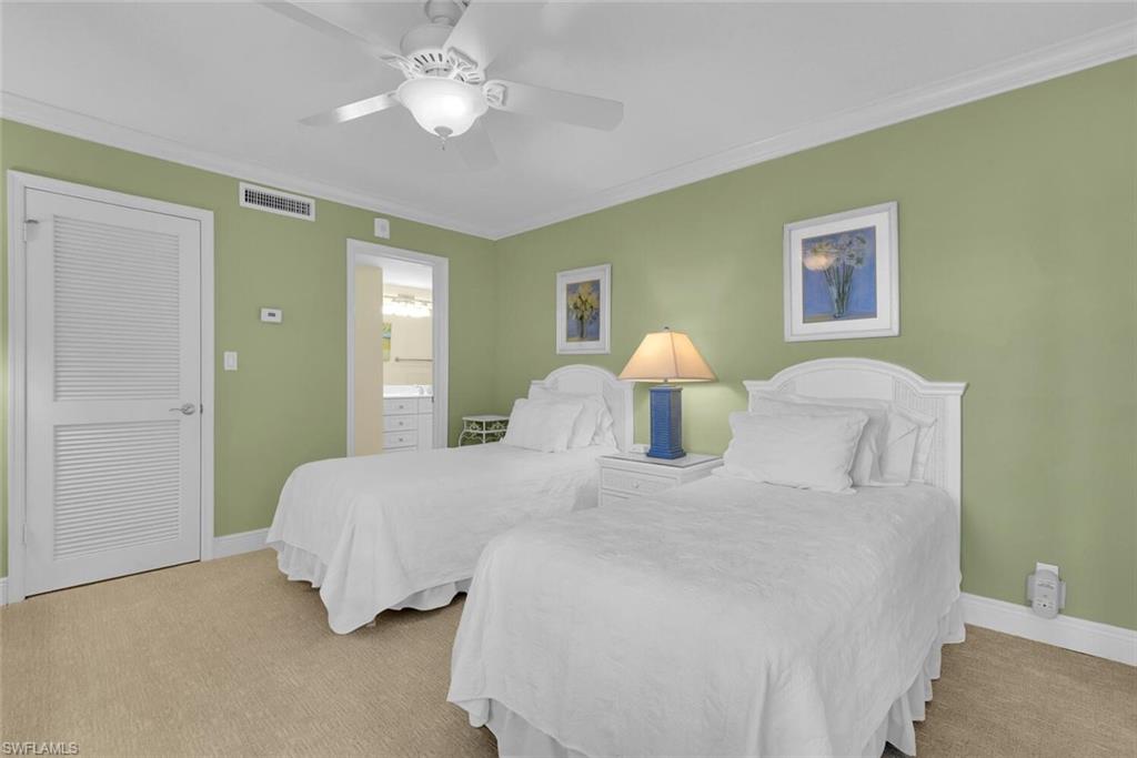 3443 Gulf Shore Boulevard North, Unit 710 Naples, FL 34103 - Photo 18 of 29 a bedroom with a bed and a chandelier