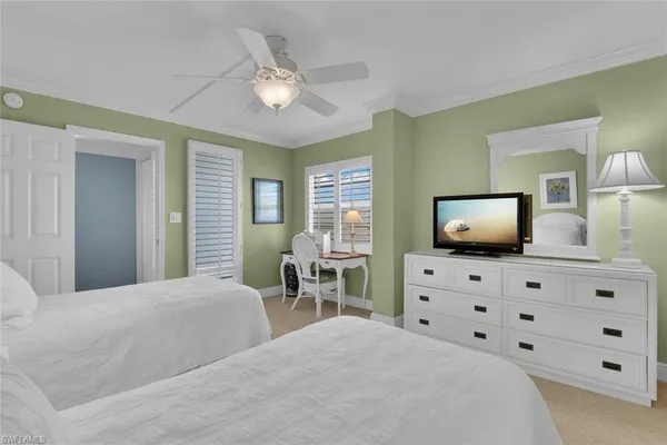 a bedroom with a bed and a flat tv screen on dresser